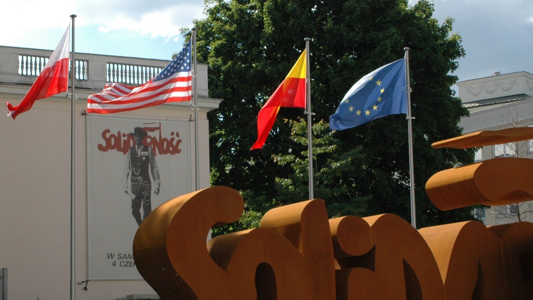 maszty aluminiowe stożkowe z flagami USA, EU, Polski i Warszawa